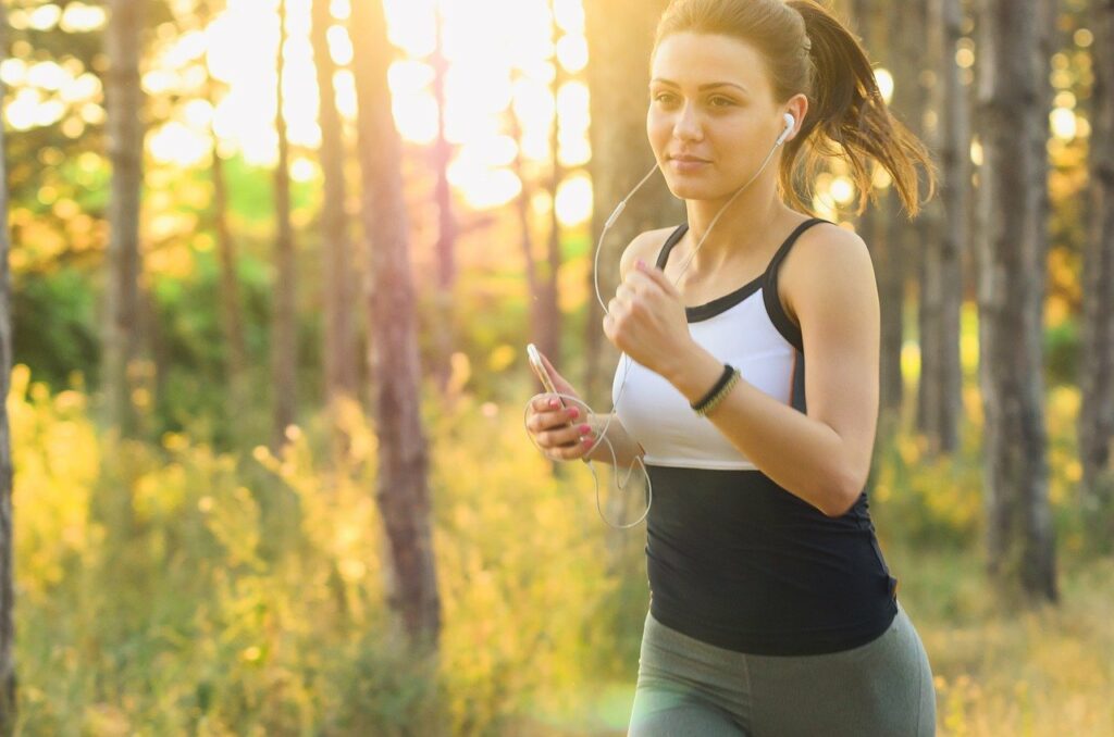 Frau joggt im grünen mit Personal Trainer in Berlin Tiergarten